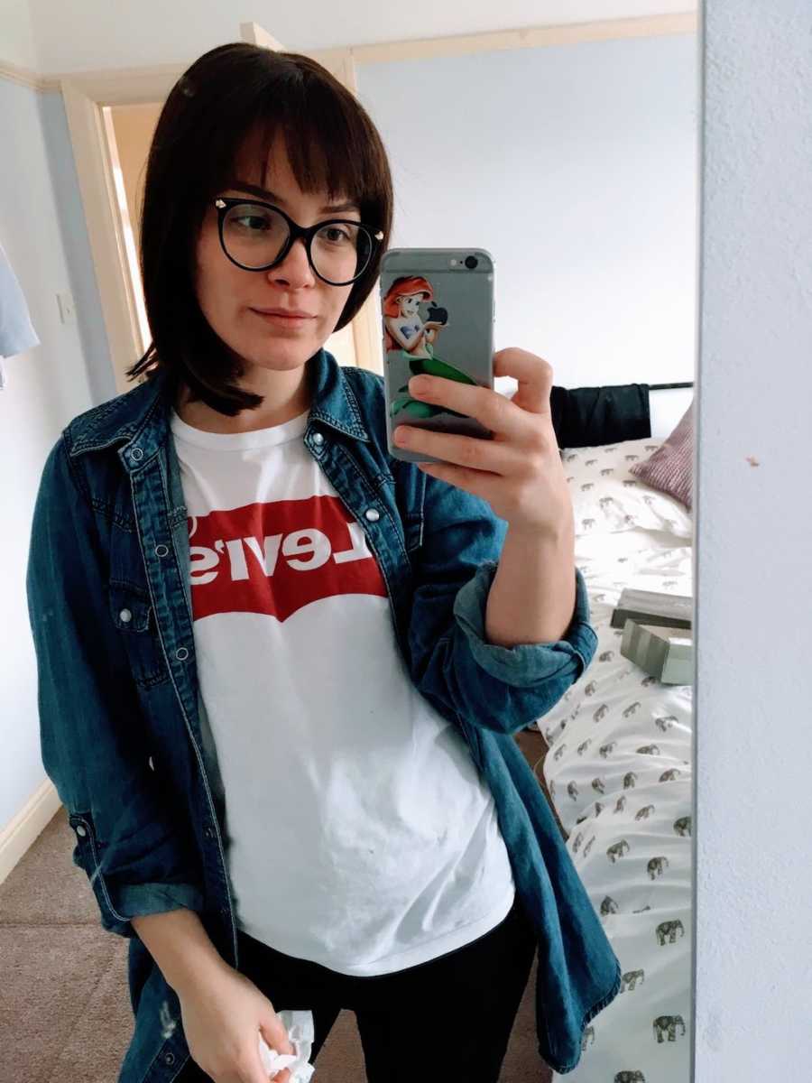 Woman wearing Levi Jeans shirt taking selfie in mirror