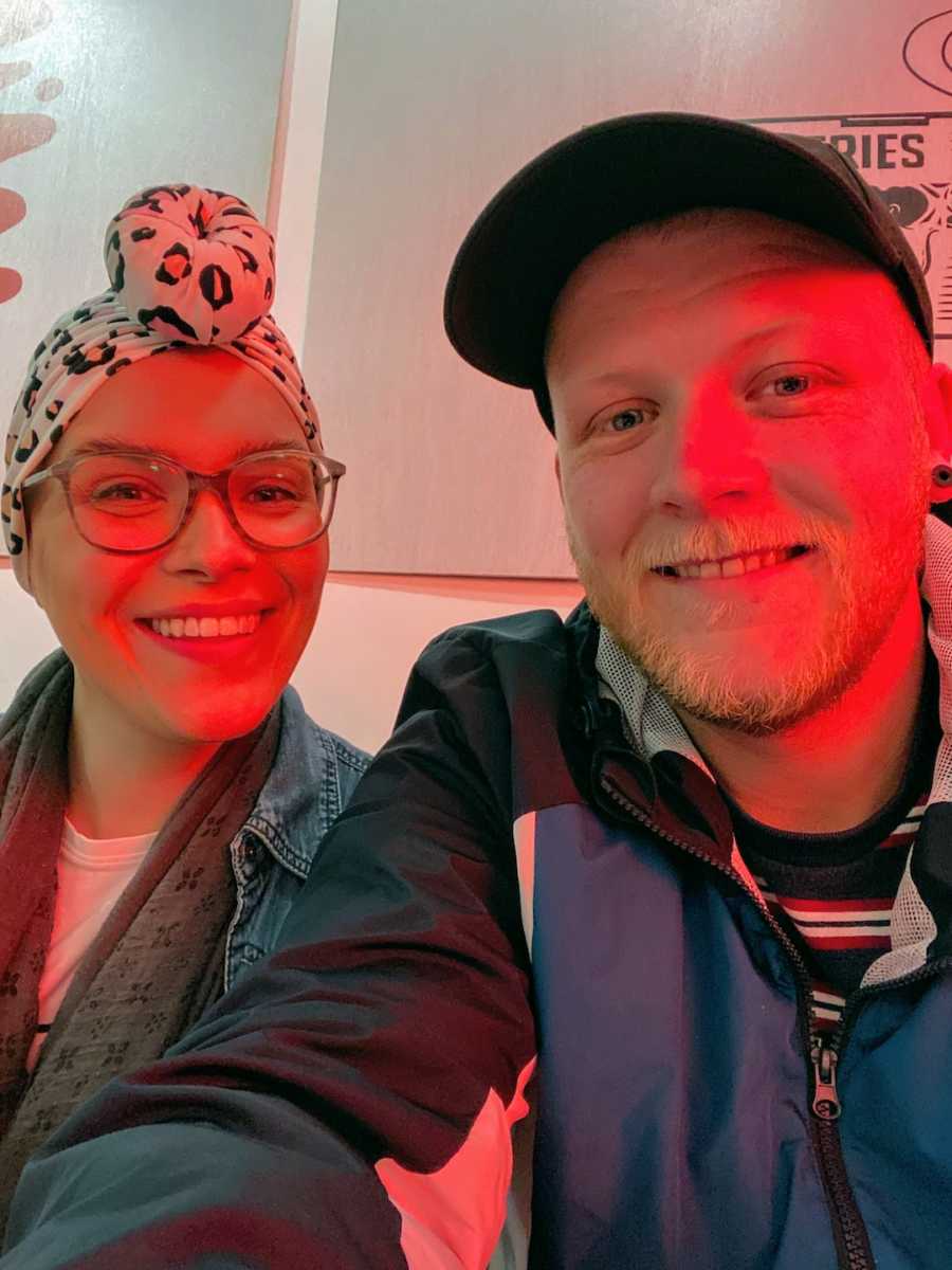 Woman wearing headwrap taking selfie with man