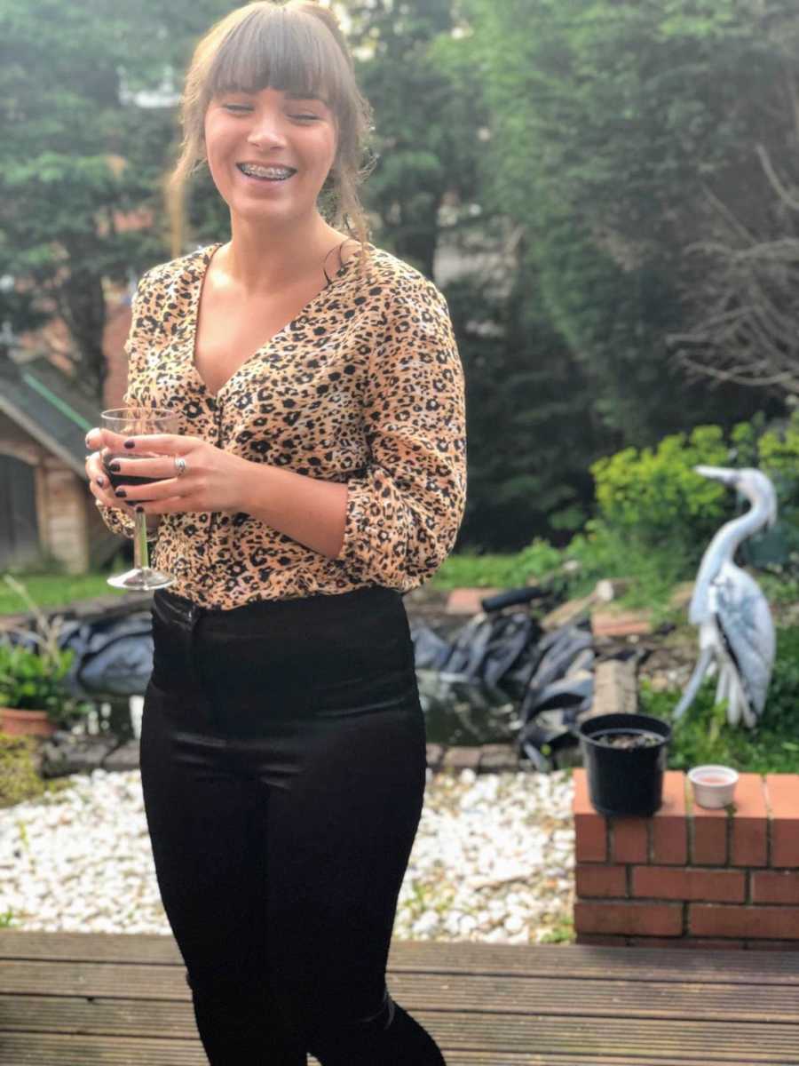 Woman smiling standing outside holding wine glass