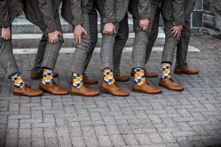 Men pulling up pants to show socks with puzzle pieces