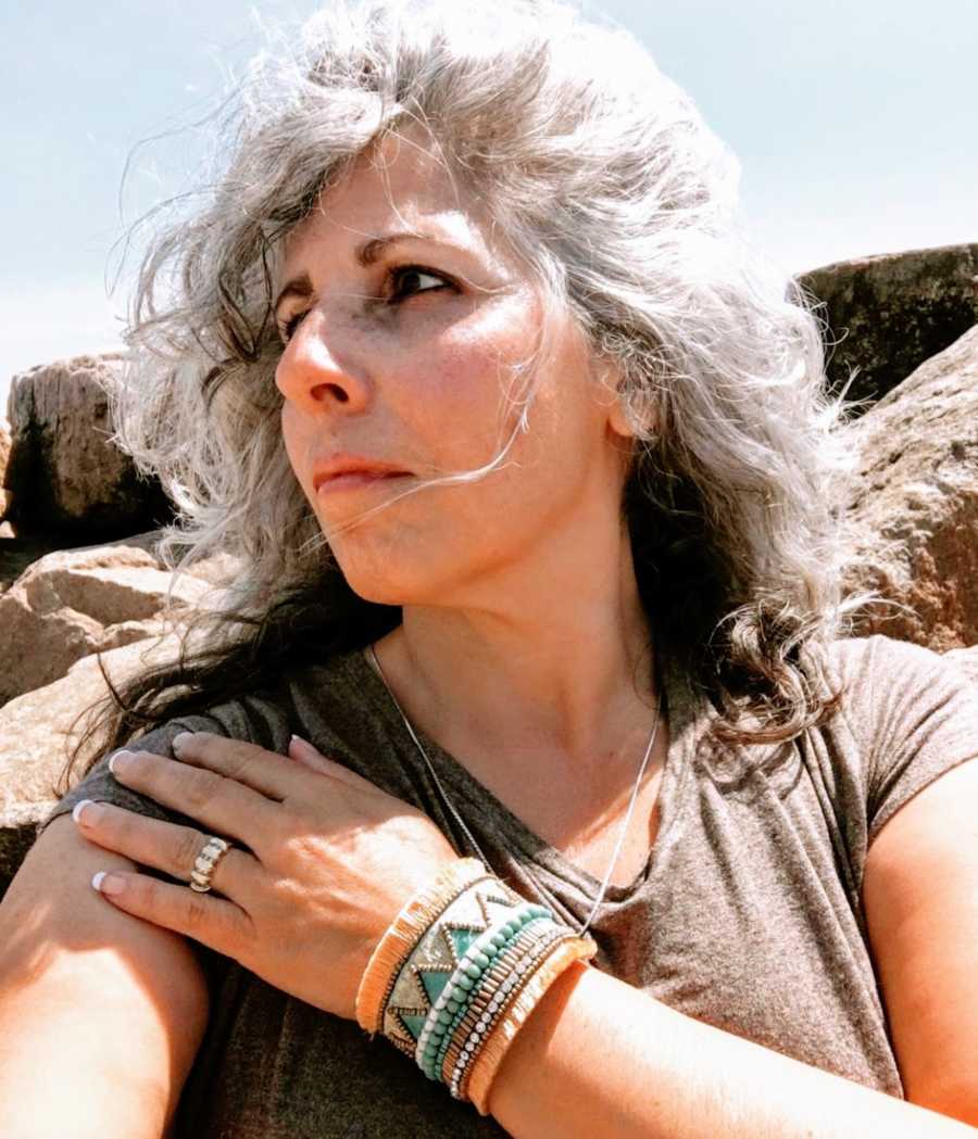 Woman with gray hair taking selfie looking off into the distance