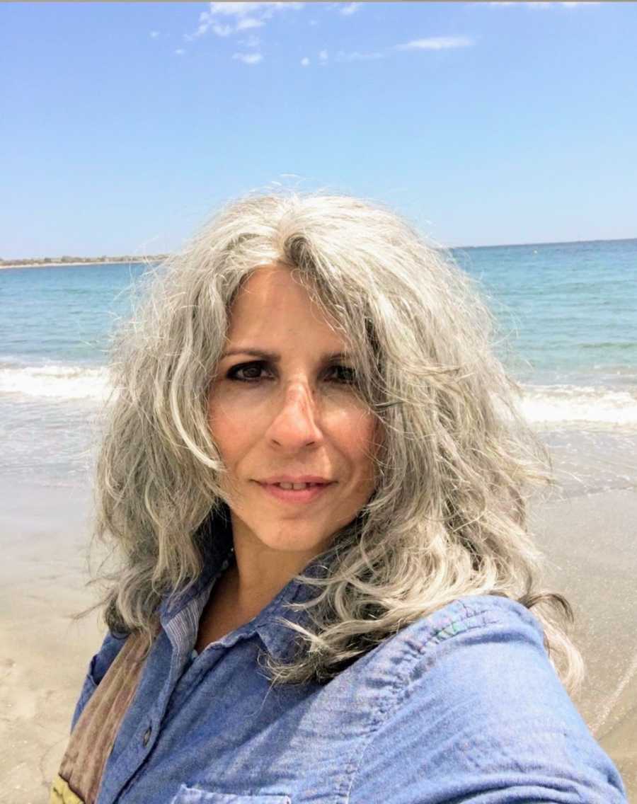 Woman with gray hair taking selfie on the beach