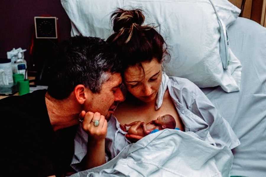 Parents look at the body of their newborn baby who is deceased