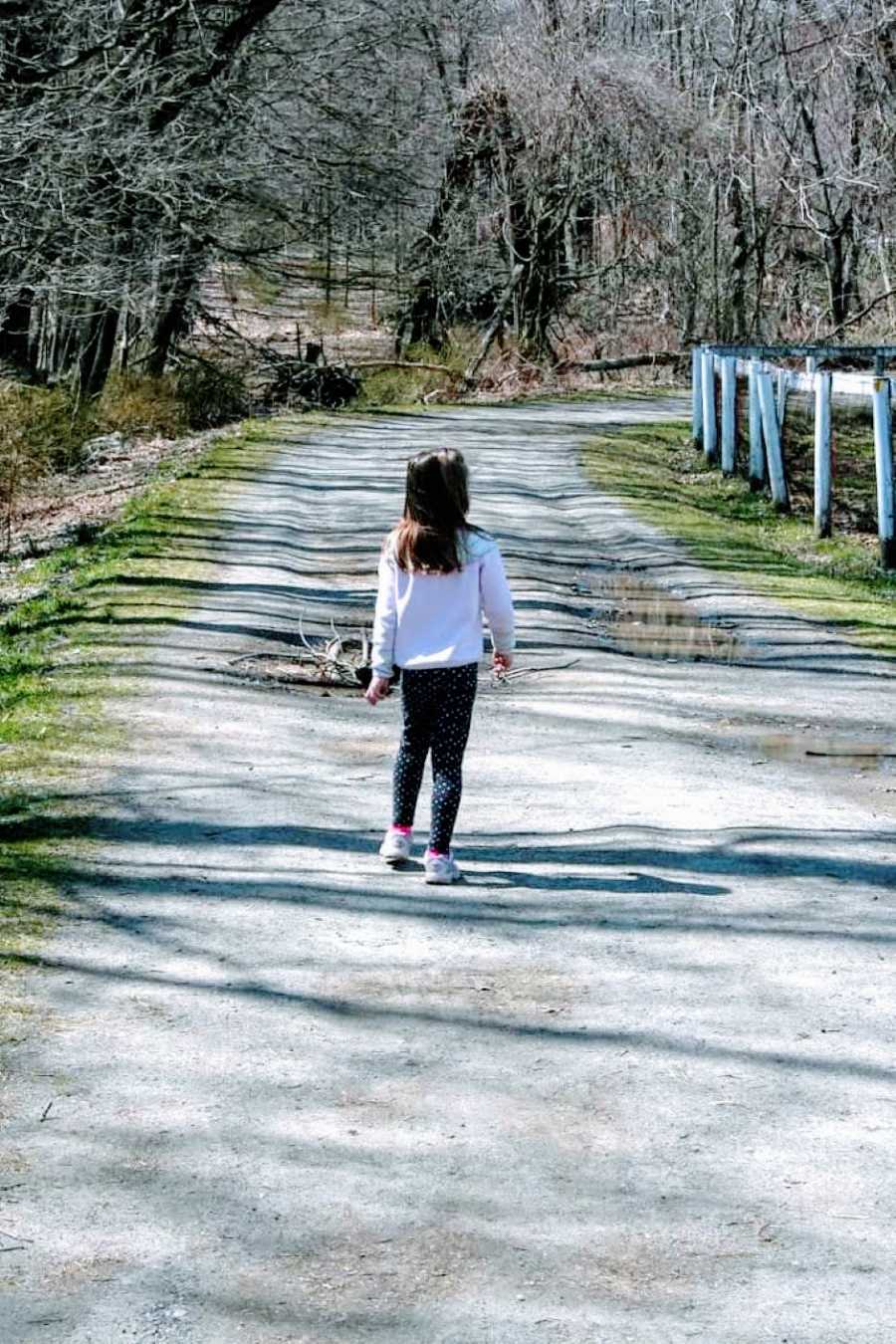 Girl mom snaps photo of her daughter running ahead of her, letting her lead the way