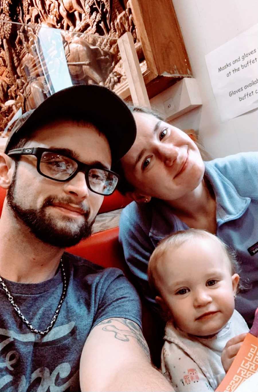 Family of three take a selfie together while out at a buffet for dinner