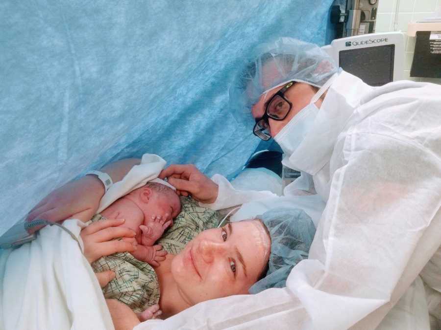 New mom and dad take a photo with their newborn daughter after mom's C-section