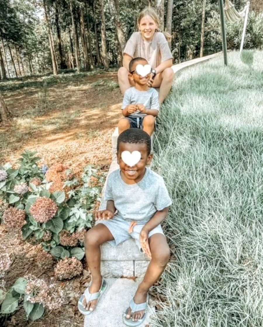 Mom takes photo of her adopted daughter and two foster sons playing in a park