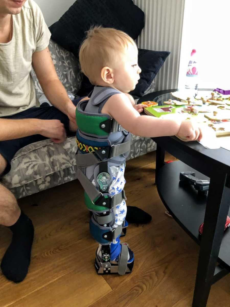 Young boy with spinal muscular atrophy practices standing during a rehabilitation exercise