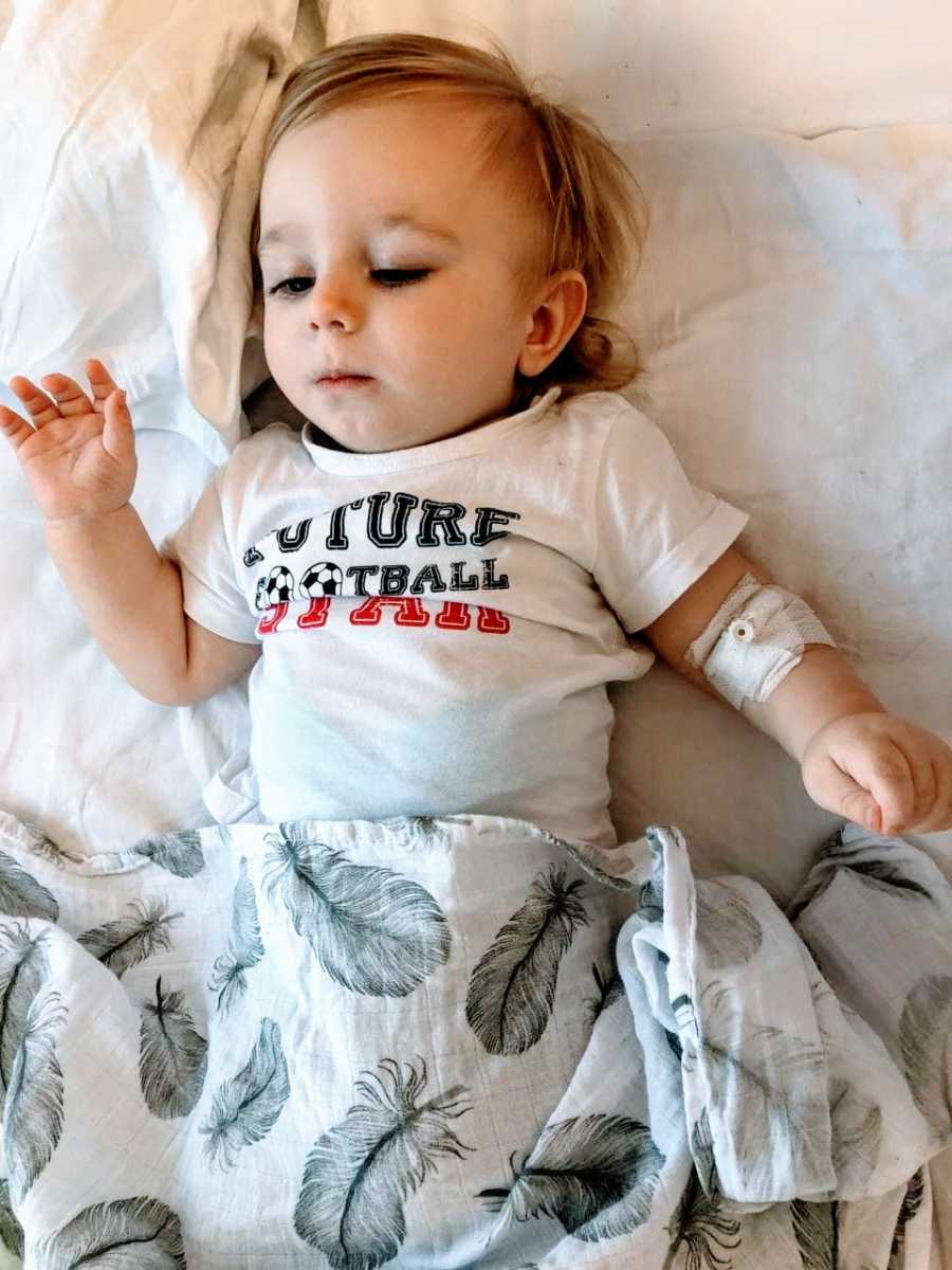 Little boy with spinal muscular atrophy lays in bed wearing a "future football star" shirt