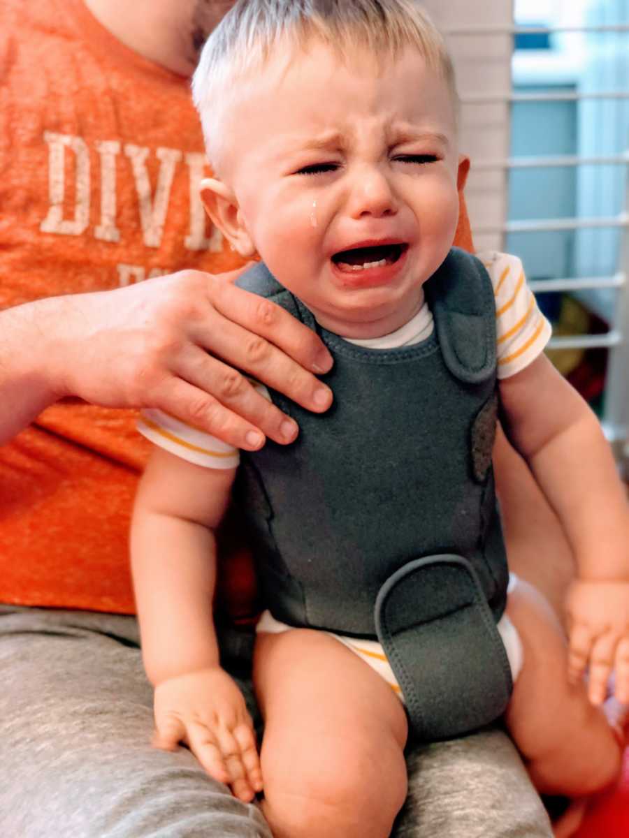 Little boy cries during rehabilitation exercise to help his spinal muscular atrophy