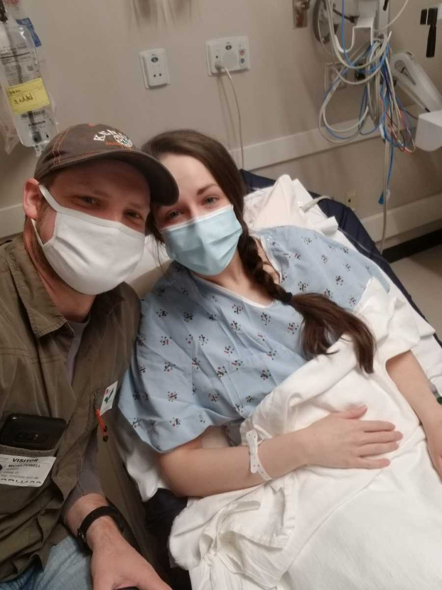 woman in hospital bed, husband beside her