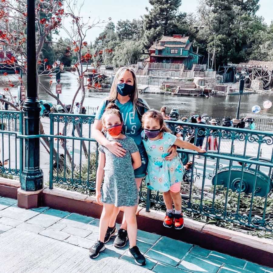 Girl mom takes photo with her two daughters while enjoying a day at Disneyland