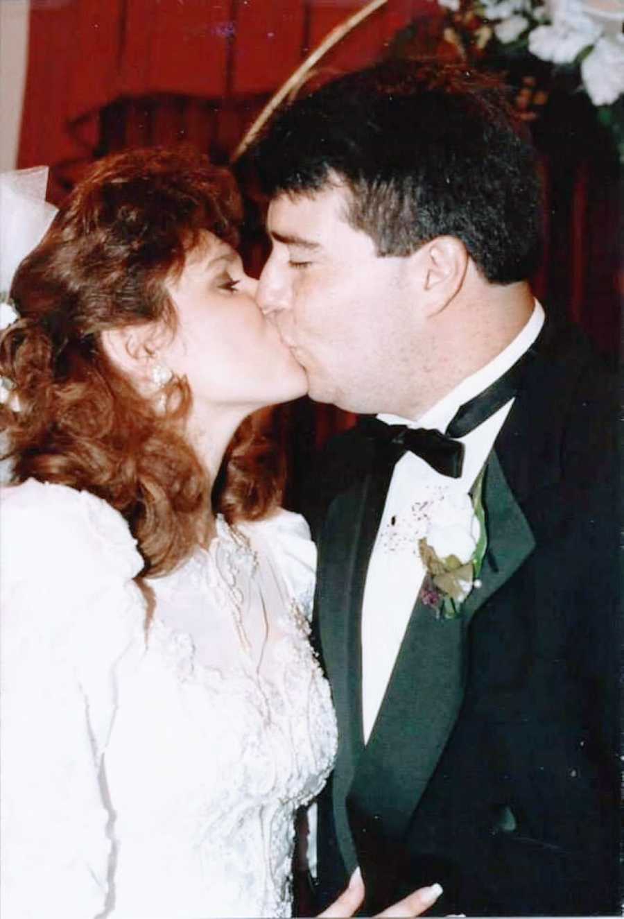 Young newlyweds share a sweet smooch at their wedding reception