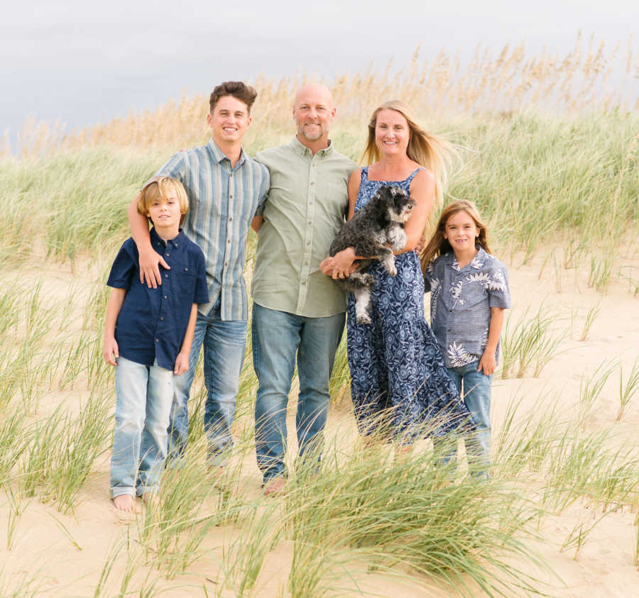 family on the beach dunes with their dog