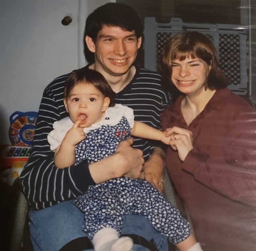 man with cerebral palsy holding his daughter, wife next to them