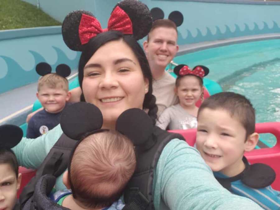 mom in mouse ears on ride with her kids