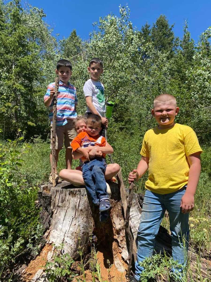 5 kids in the forest on a tree stump