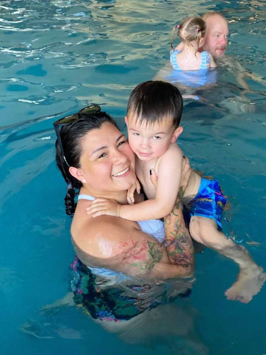 woman holding her son in the pool