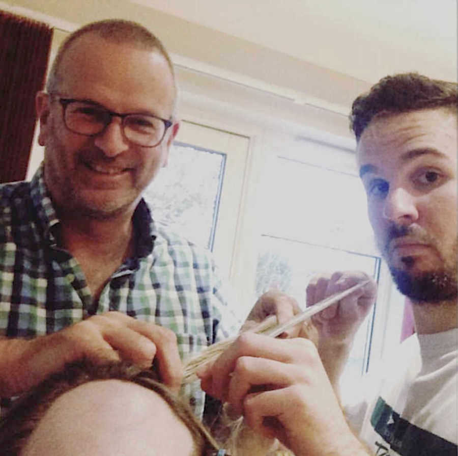 two men shaving a girl's head