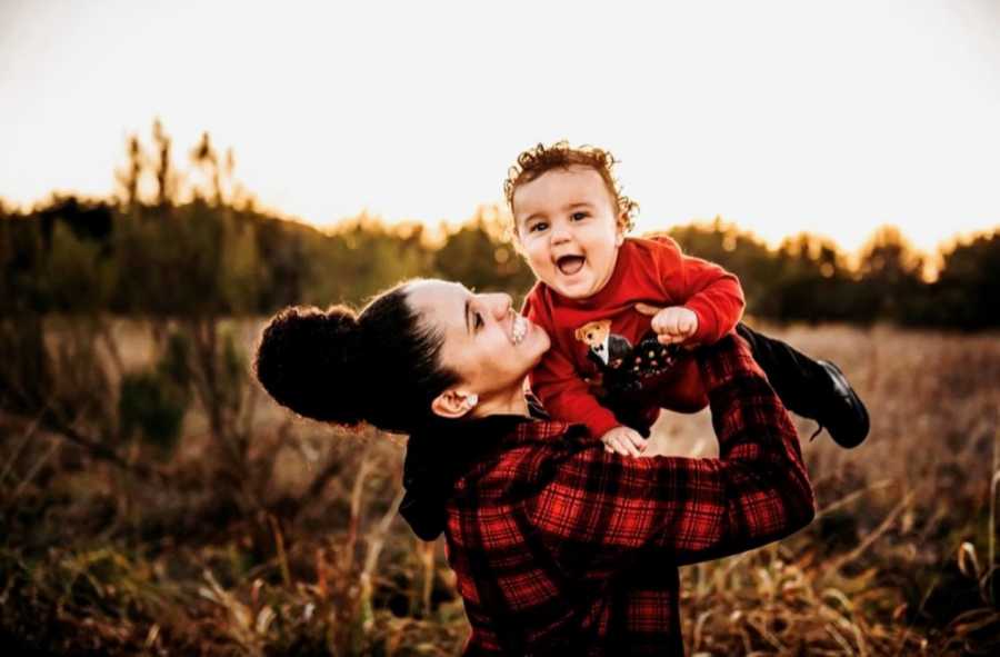 Lesbian woman smiles while holding her toddler son conceived through IUI