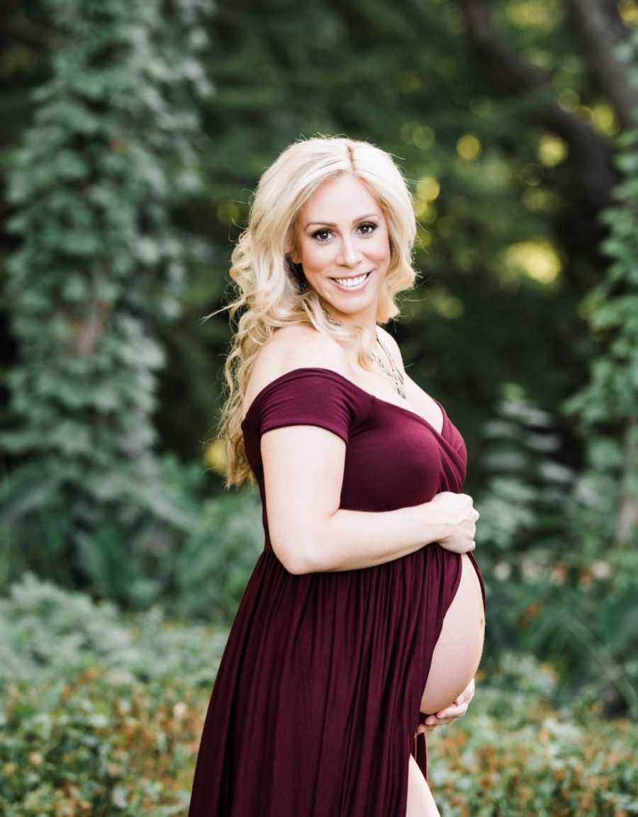 maternity photo of woman in red dress outside