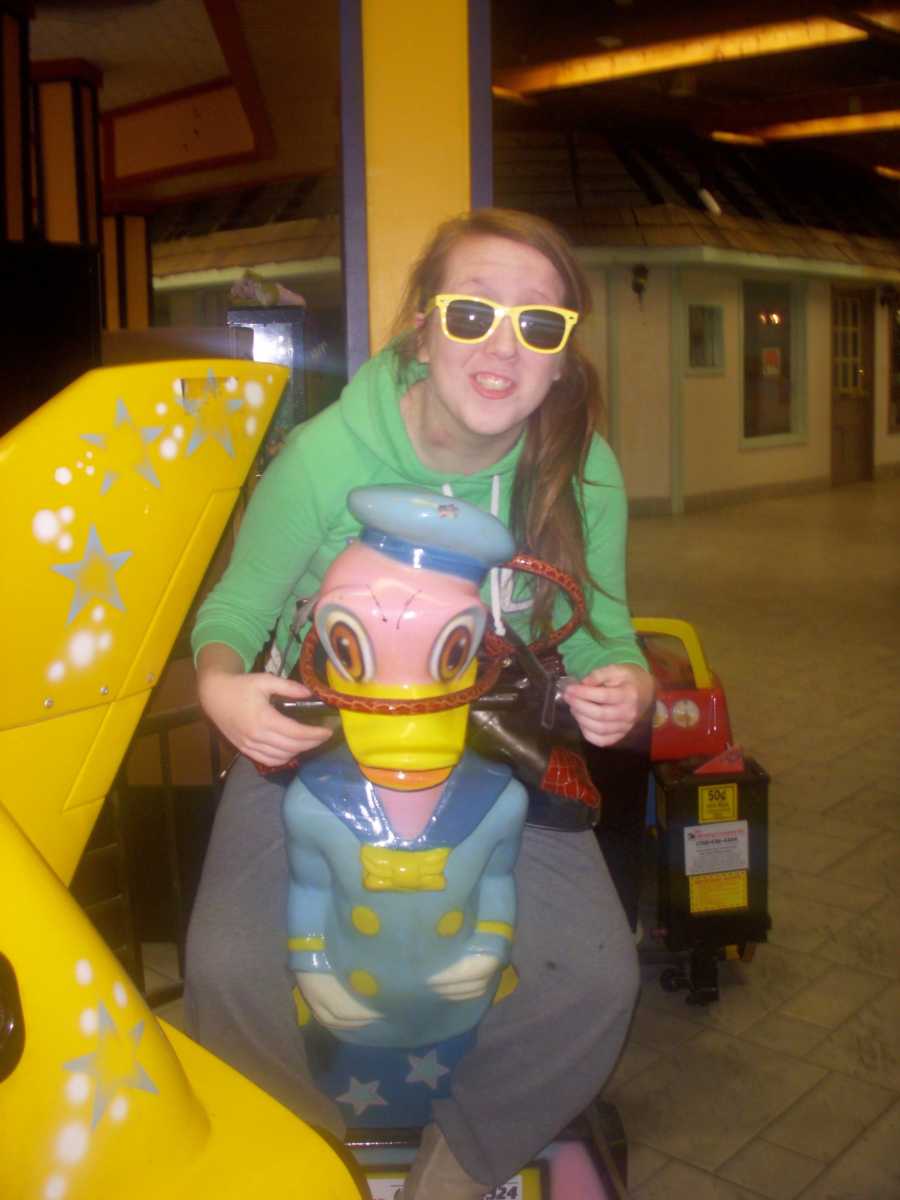 girl sitting on an arcade game