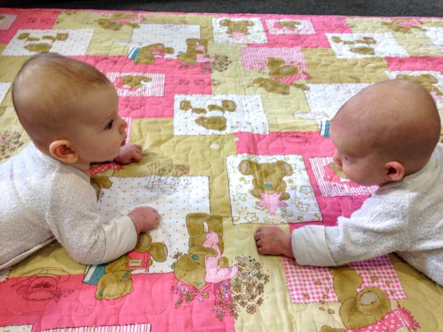 Mom snaps photo of twin daughters learning to crawl and hold their heads up during tummy time