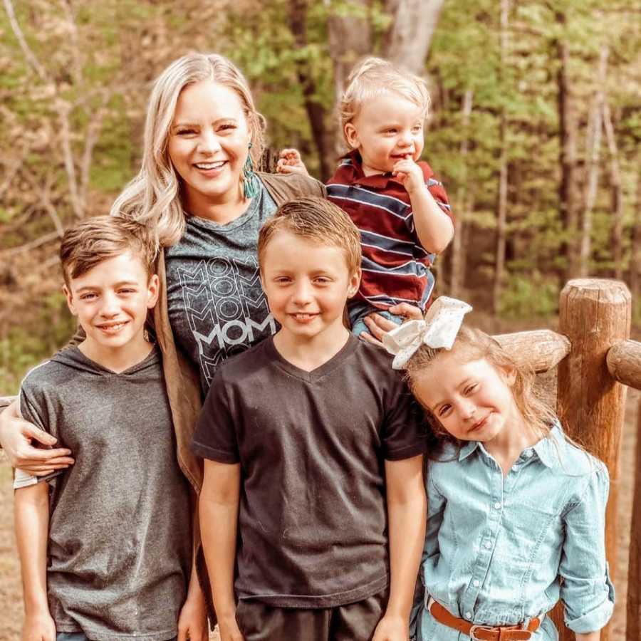 Young mom of four takes a photo with her kids on the back porch of her dream home