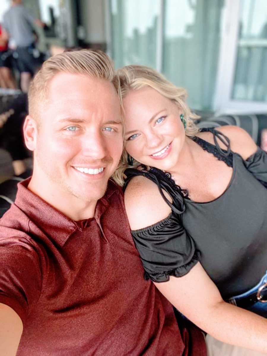 Young married couple advocating for postpartum depression awareness take a selfie together while sitting on a balcony