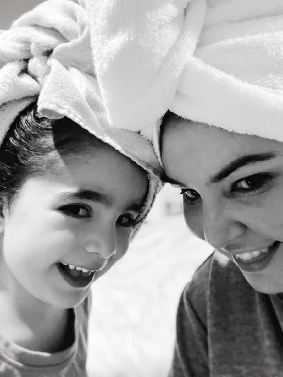 Mom takes a selfie with her daughter with their hair wrapped up in towels