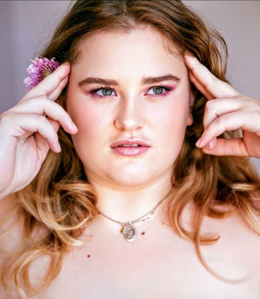 A young woman posing with a flower in her hair