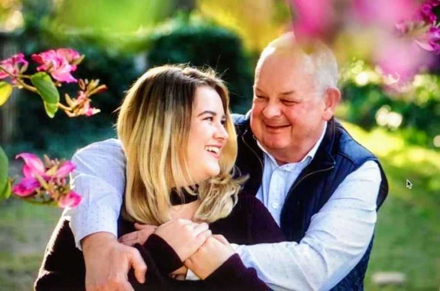 A young woman and her father surrounded by flowers