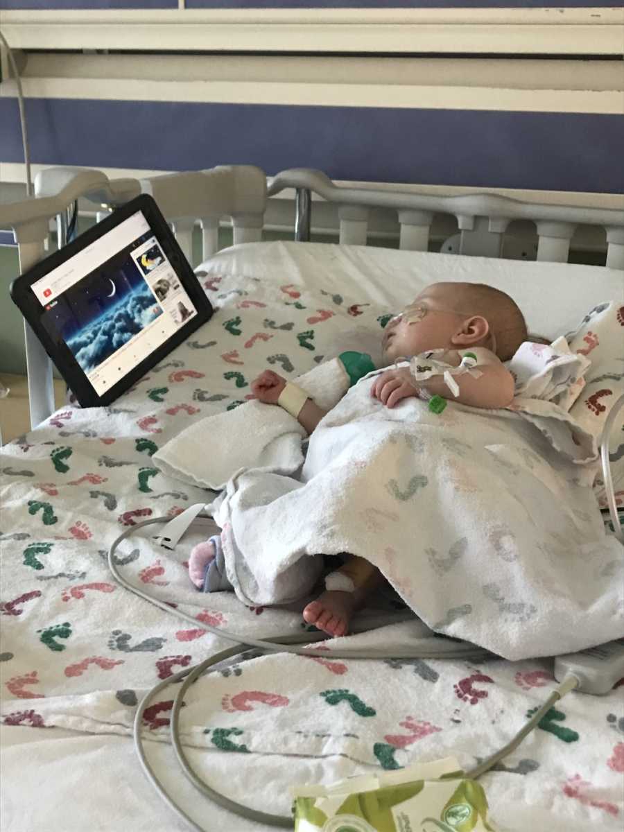 baby watching a tv under blanket