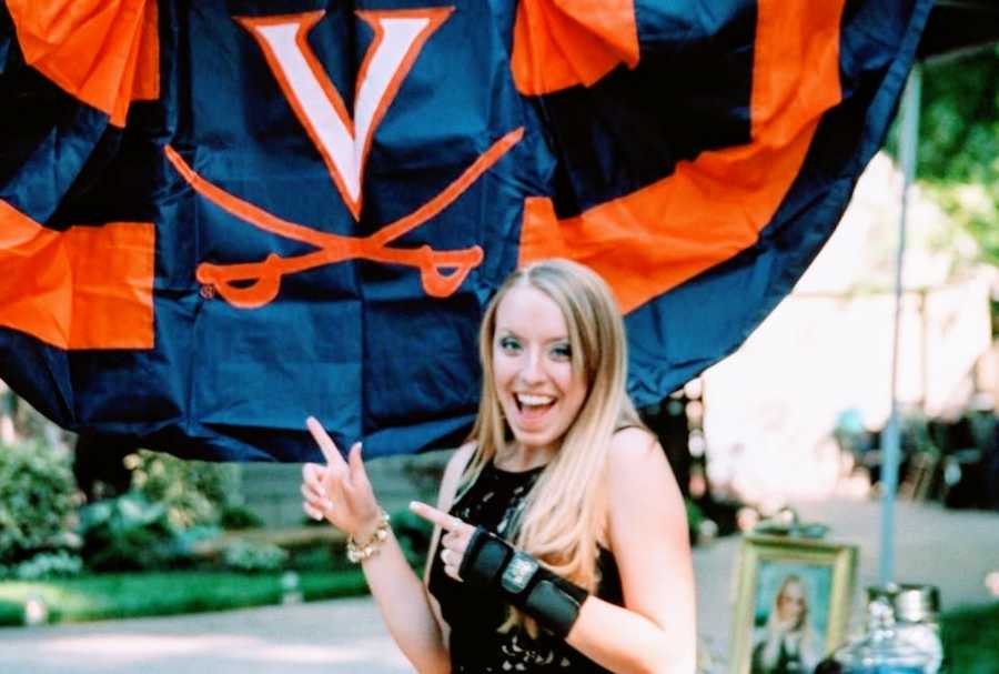 Teen girl take a photo smiling and pointing at a flag with Kinesio tape wrapped around her wrist