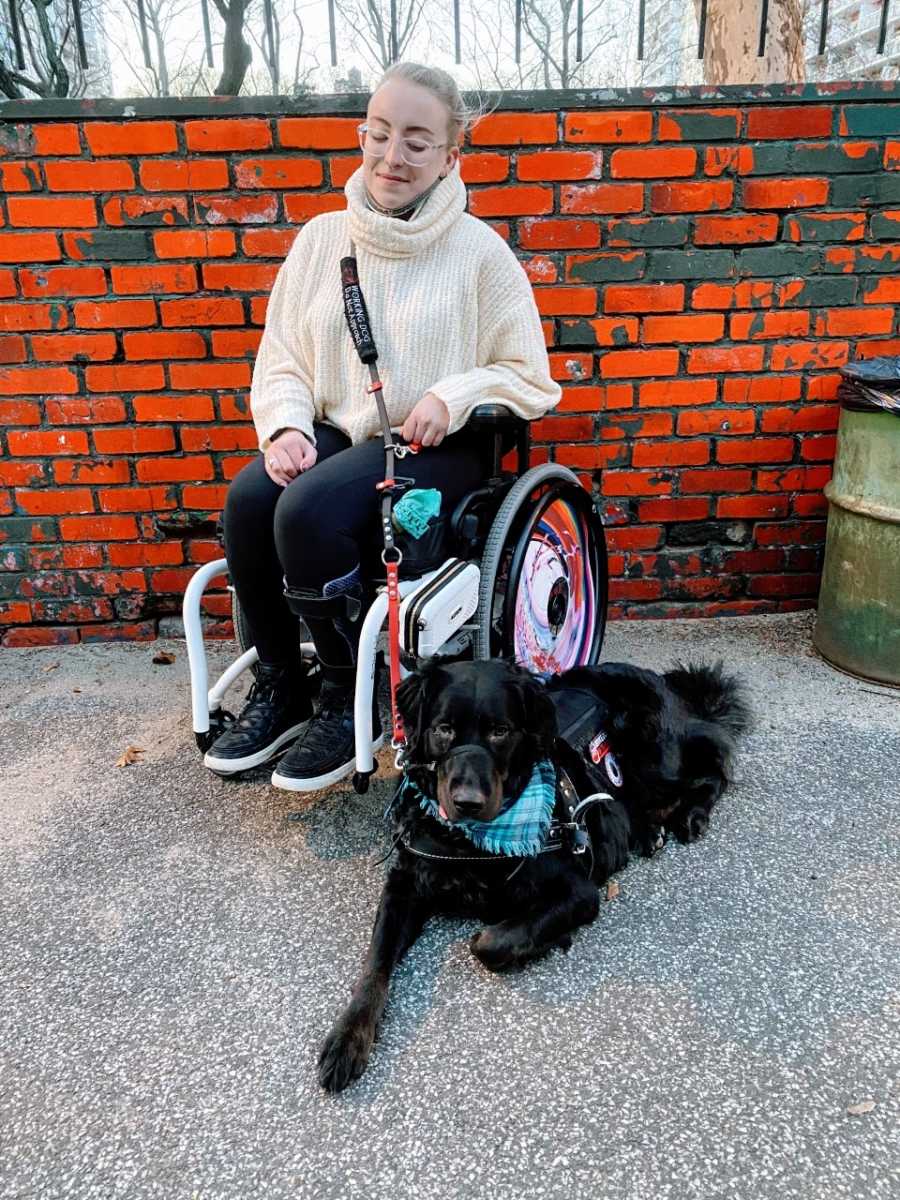 Young college student takes a photo with her service dog