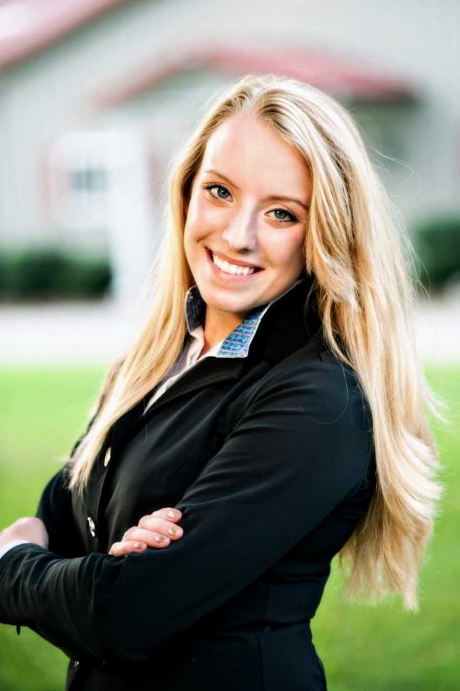 Young blonde woman takes headshot in professional style jacket