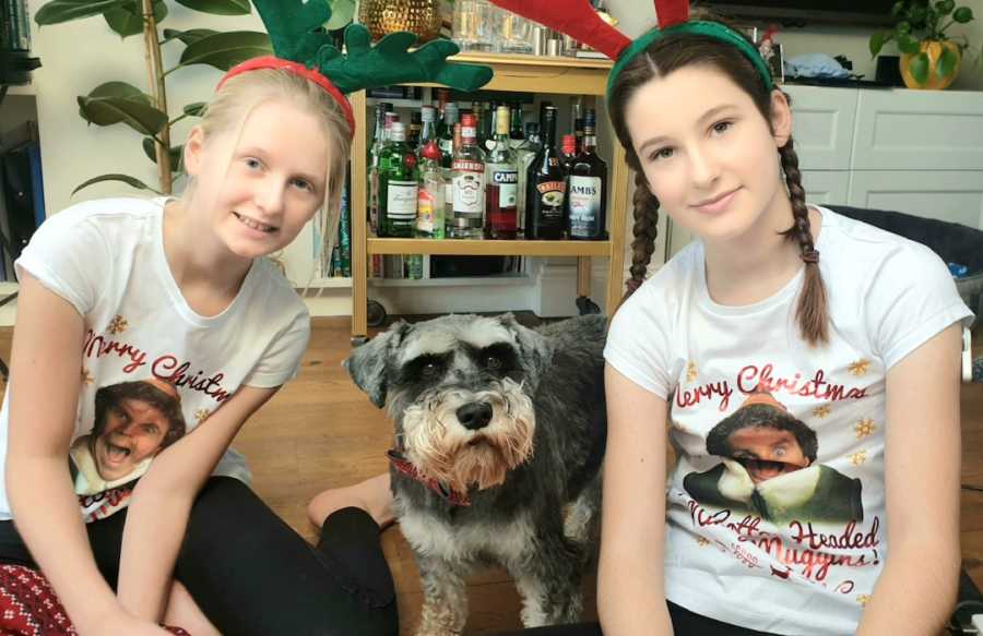 sisters in reindeer antlers with dog