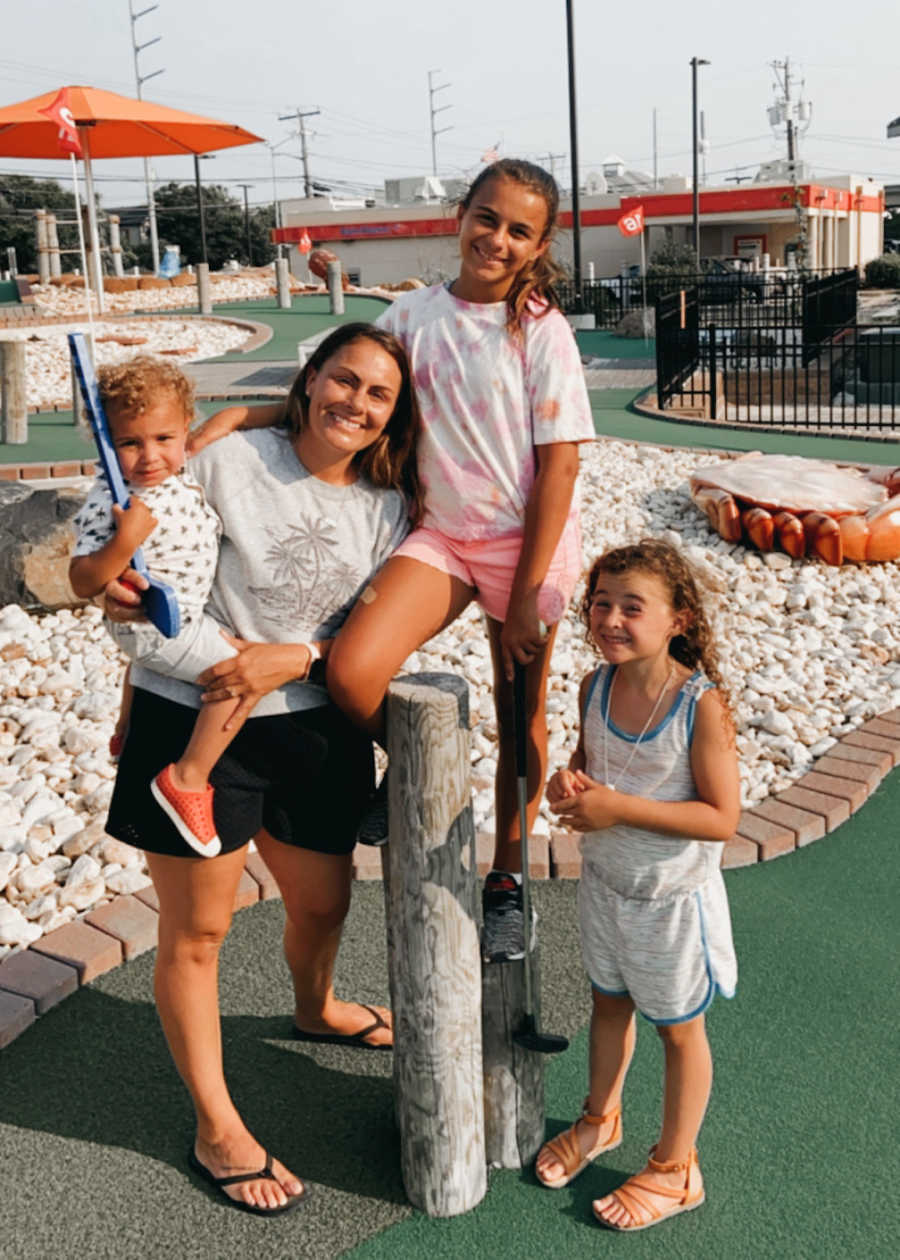 family standing in a mini golf course