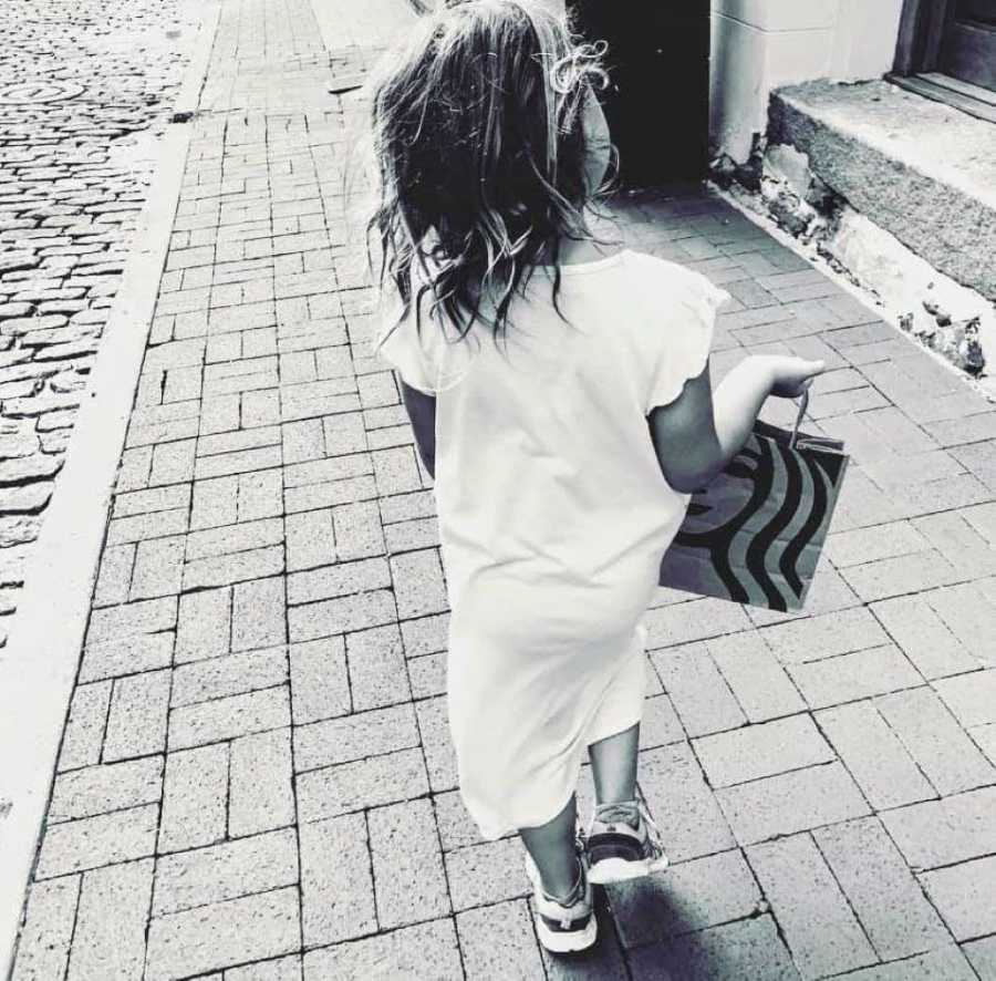 Mom of three snaps a photo of her youngest daughter walking down the sidewalk in a long dress