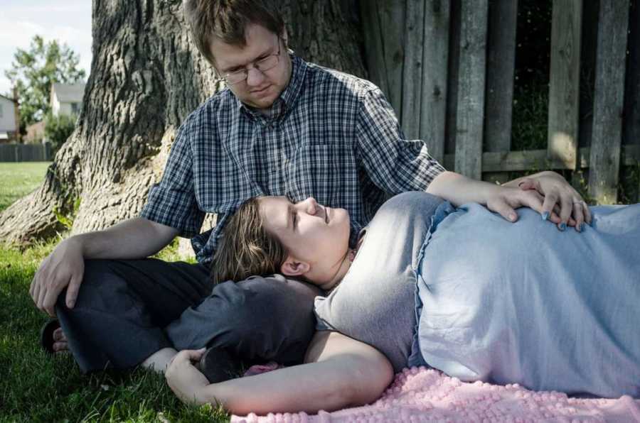 couple laying by a tree