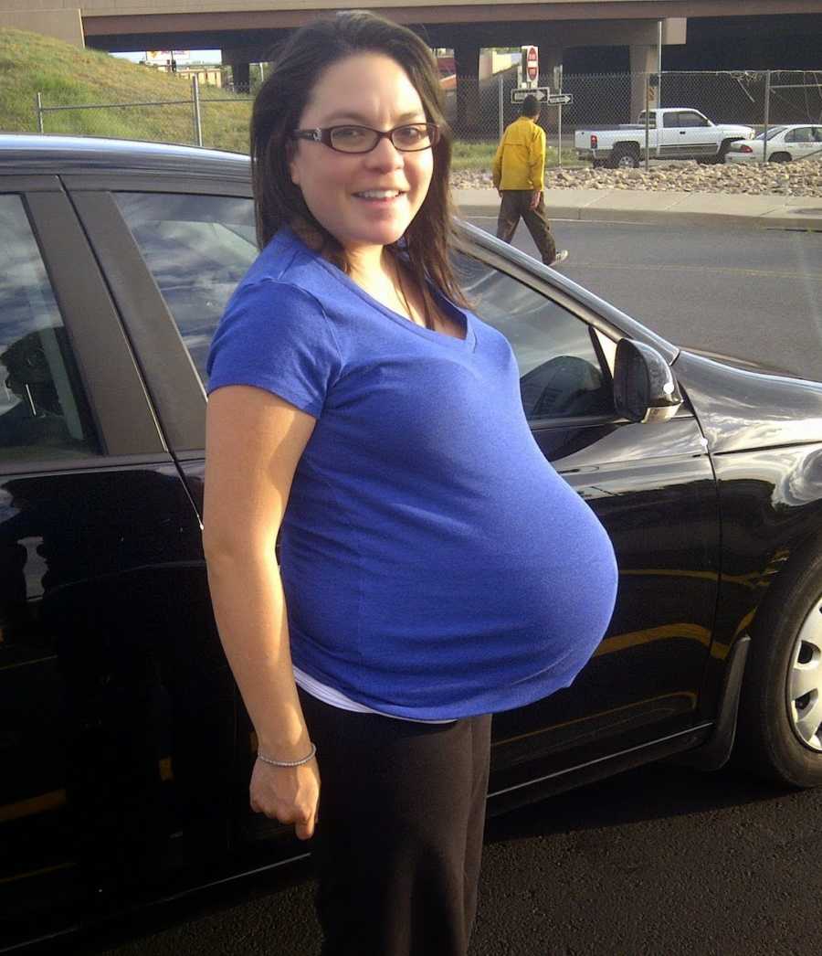 maternity photo of woman smiling in blue shirt