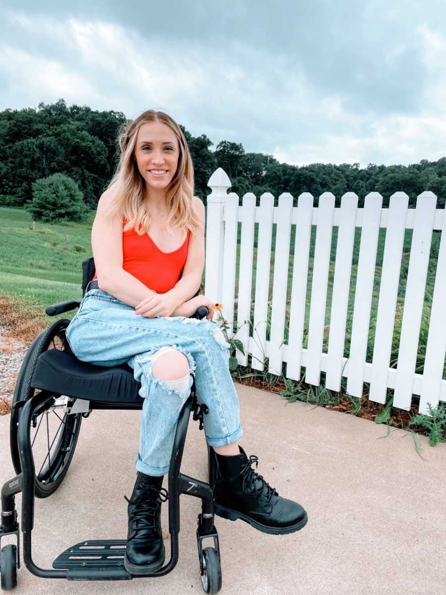 Woman smiles big for a photo while sitting in her wheelchair