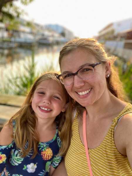 Mom takes selfie with diabetic daughter in front of beautiful waterfront scenery