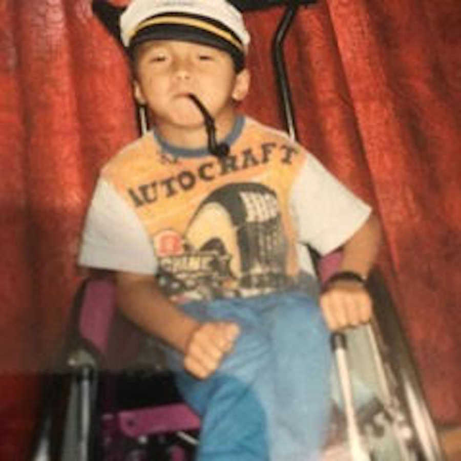 young boy in wheelchair with toy pipe