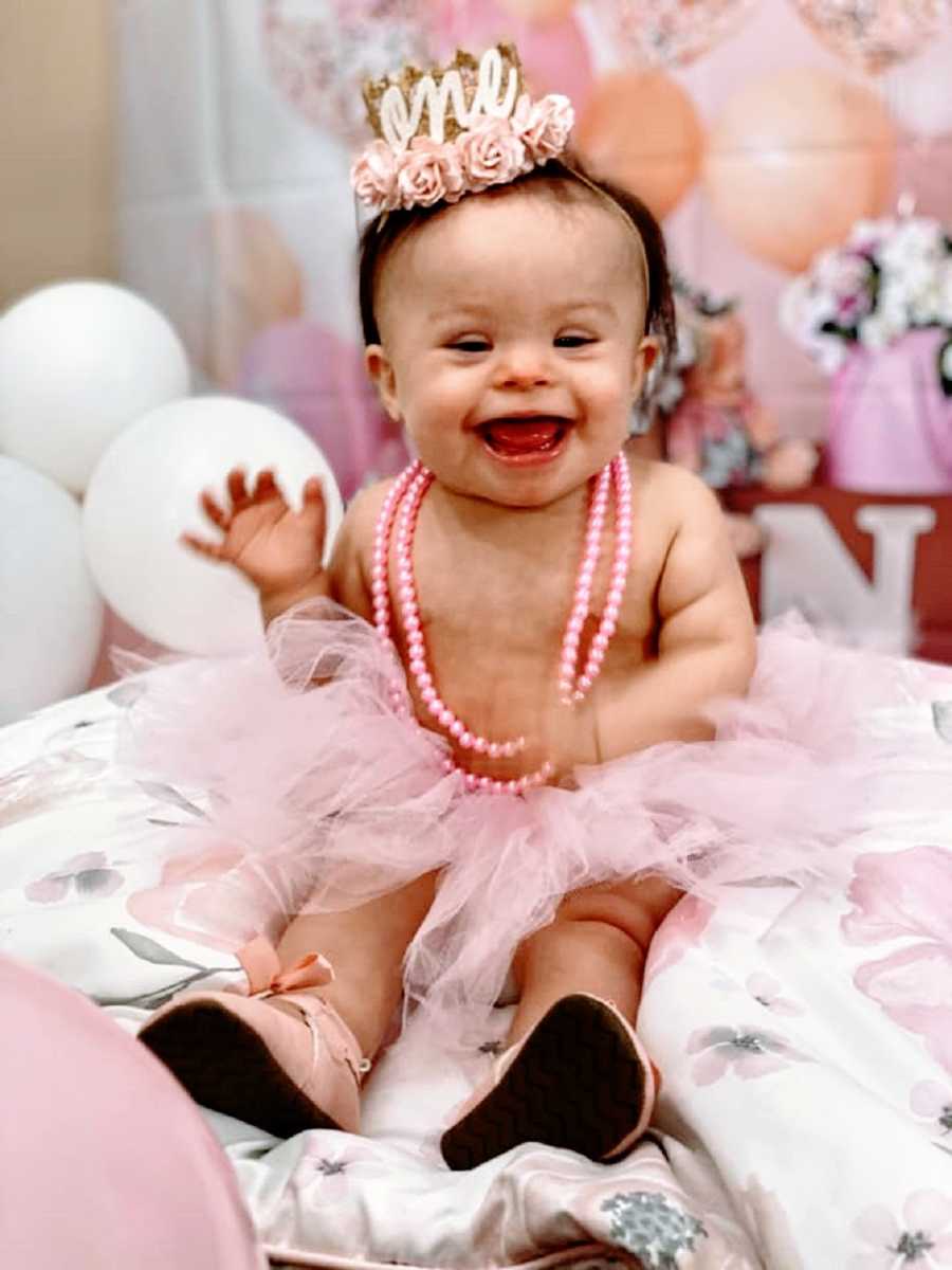 A little girl with down syndrome wearing a tutu