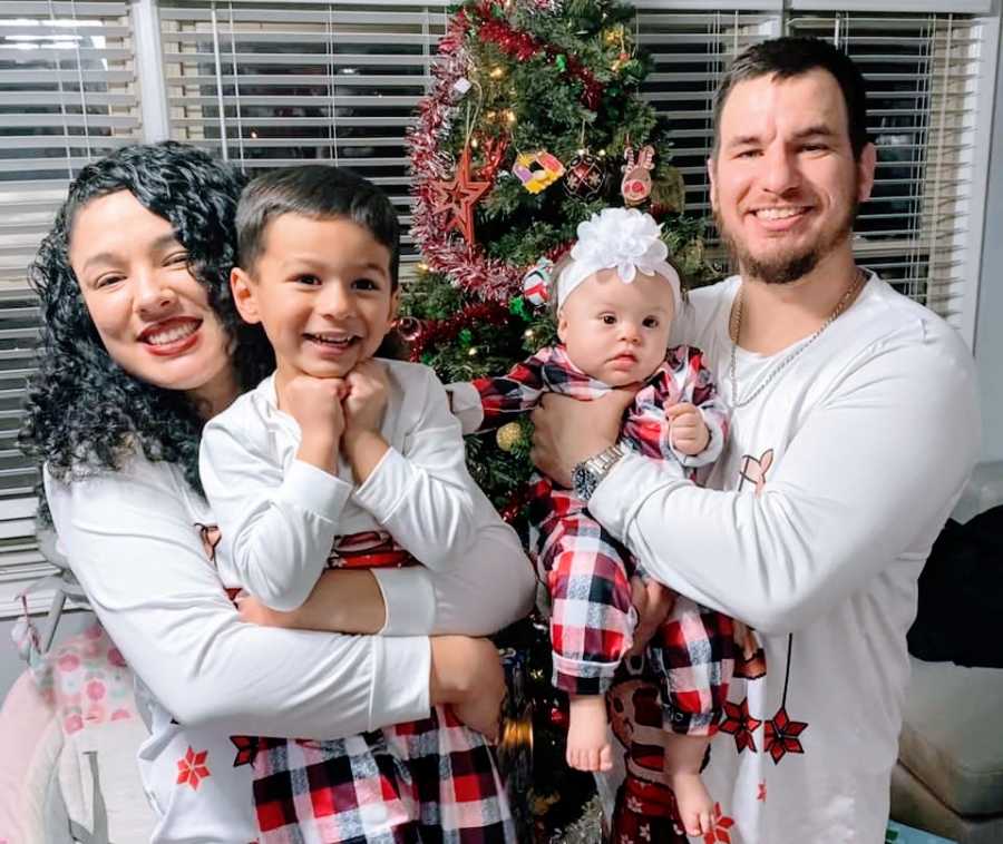 Parents hold up their son and baby daughter