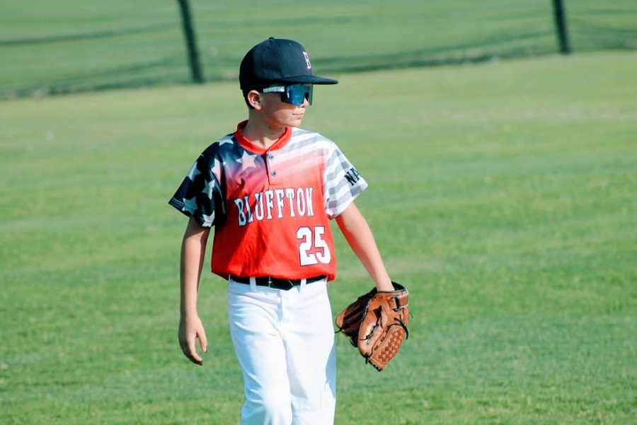 A boy wearing his all-star baseball jersey