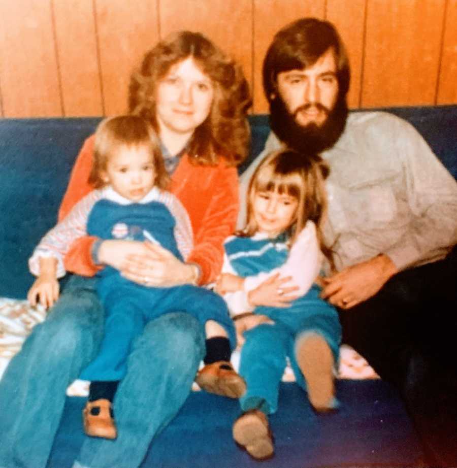 Parents sit with their two young daughters