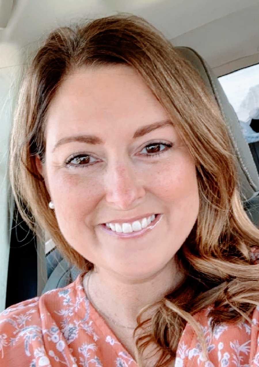 A woman sitting in a car and smiling