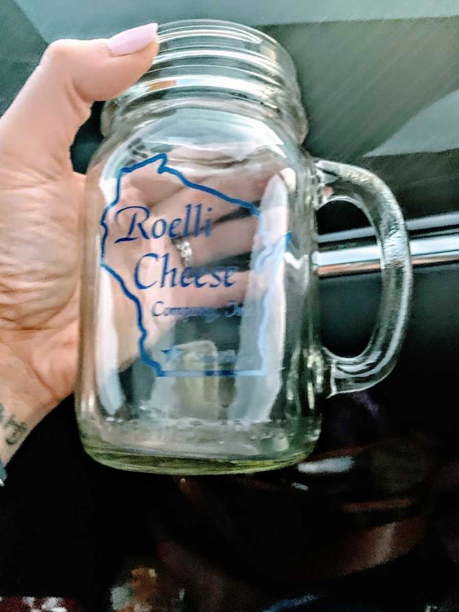 A Mason jar with a cheese business logo on it